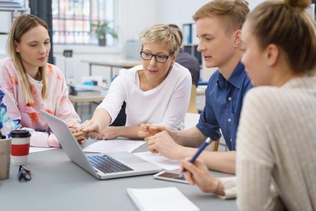 Menschen im Büro sitzen gemeinsam an einem Tisch