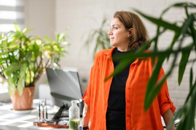 Frau vor Büropflanzen nachdenklich