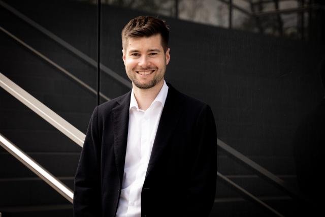 Mann in Anzug lächelt in Kamera