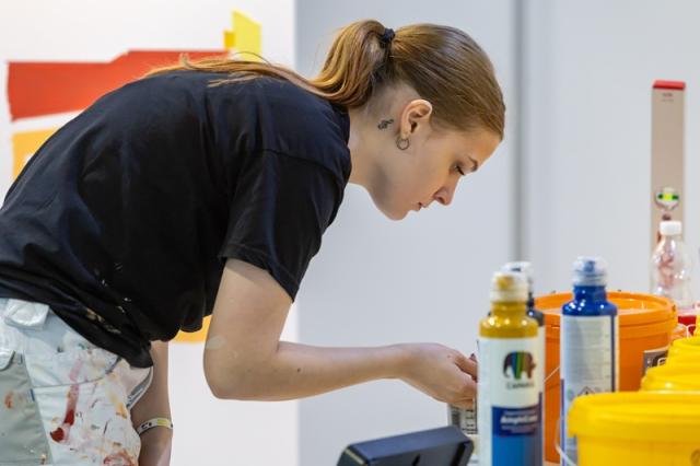 Weiblicher Malerlehrling bei der Arbeit