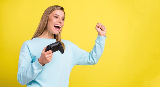 Frau jubelt mit Konsolensteuerung in der Hand